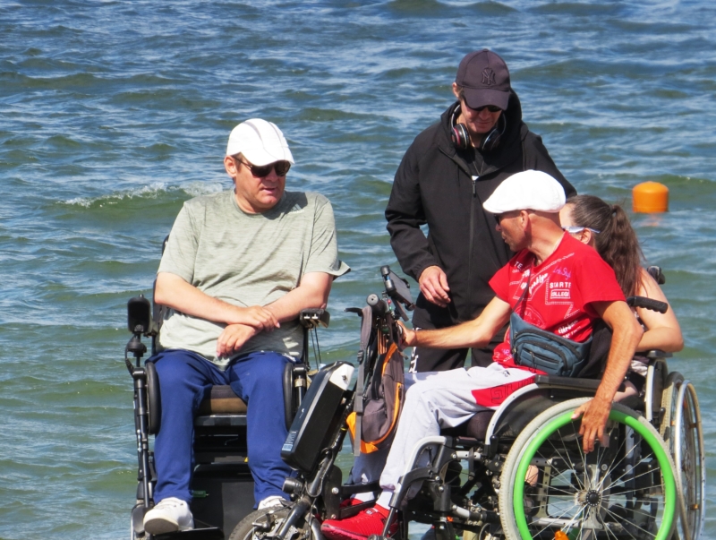 Инвалид колясочник. Машина для спуска инвалидов в море. 2 Инвалида. Два инвалида колясочника едут.