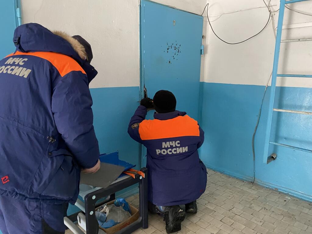 Спасатели МЧС деблокируют дверь при помощи аварийно-спасательного инструмента